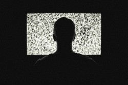 A man watches a blank television screen.